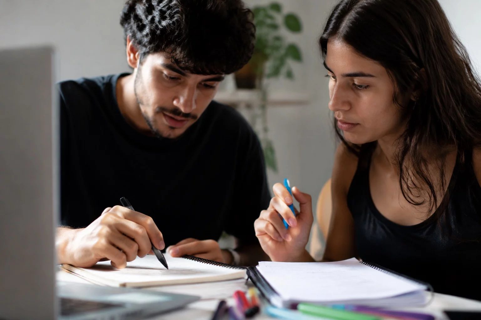 Dois estudantes preparando um debate com cadernos e marcadores